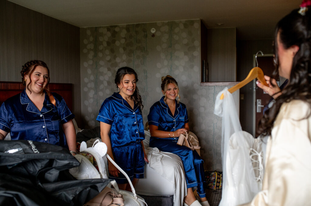 bride showing bridesmaids her dress