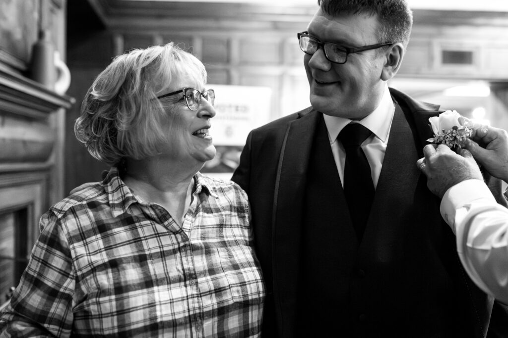 groom and mom smiling at each other