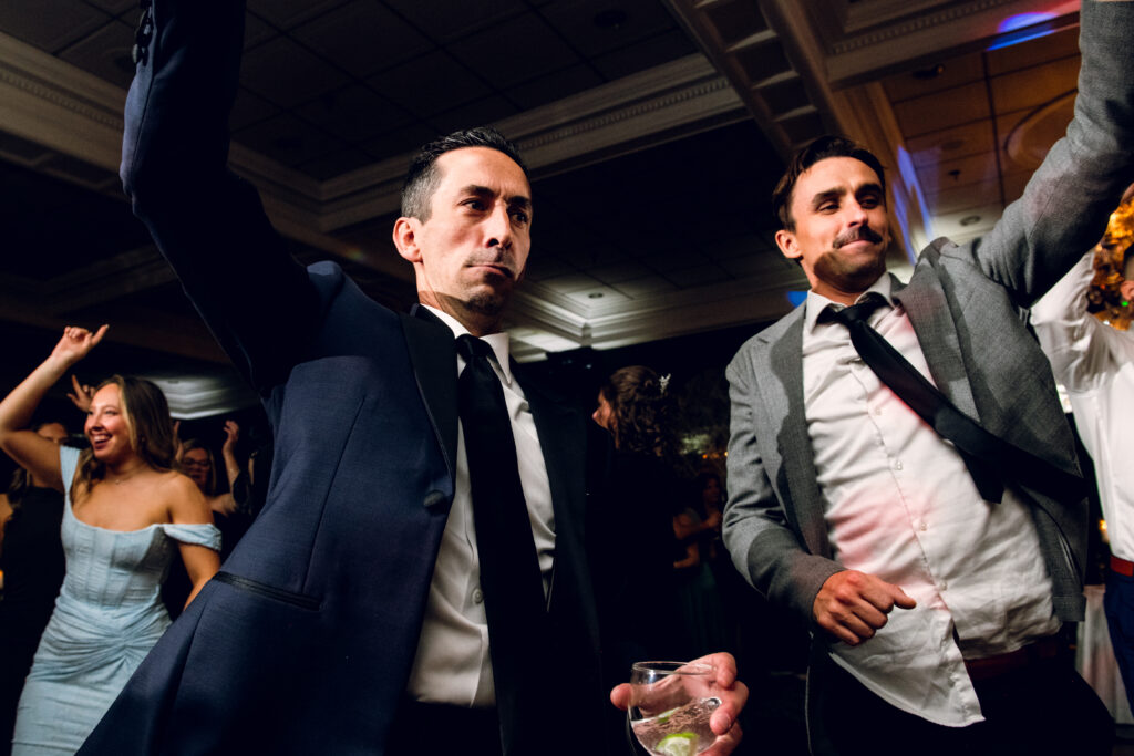 two men dancing with arms raised