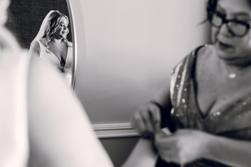 bride and bride's mom fixing a dress