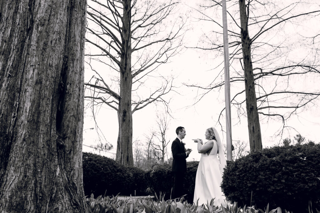 bride and groom talking near trees