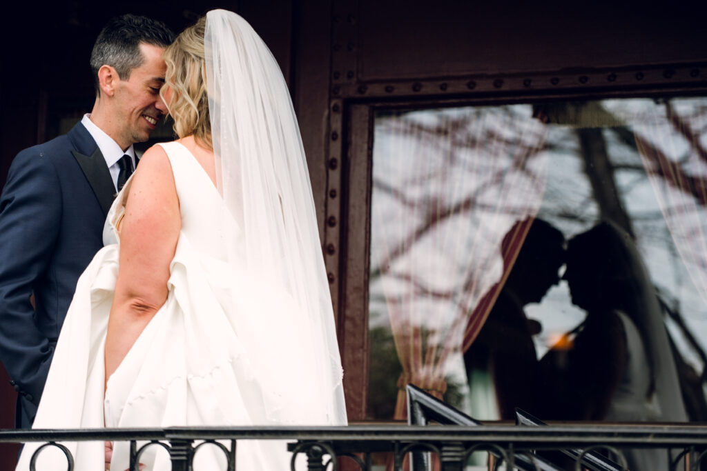 bride and groom's reflection in glass