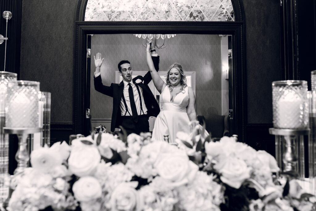 bride and groom cheering as they enter a room