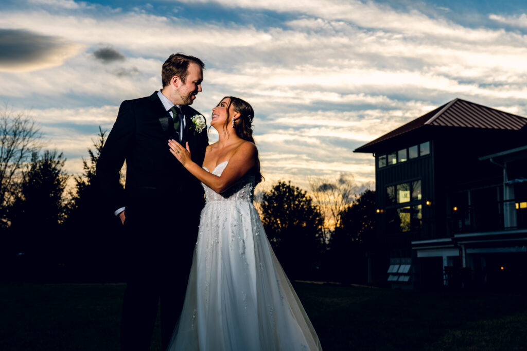 bride and groom looking at each other with a sunset behind bear brook valley
